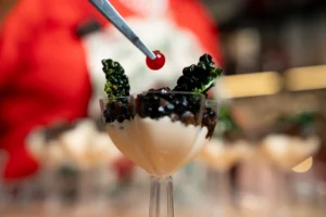 Lenticchie nere Beluga servite come finger food di Capodanno 2026, con crema di anacardi e cavolo nero croccante.