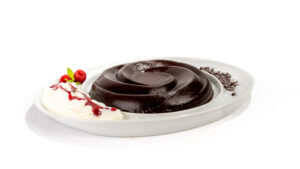 Budino al cacao vegetale sformato su piatto da portata, dessert semplice e senza latticini