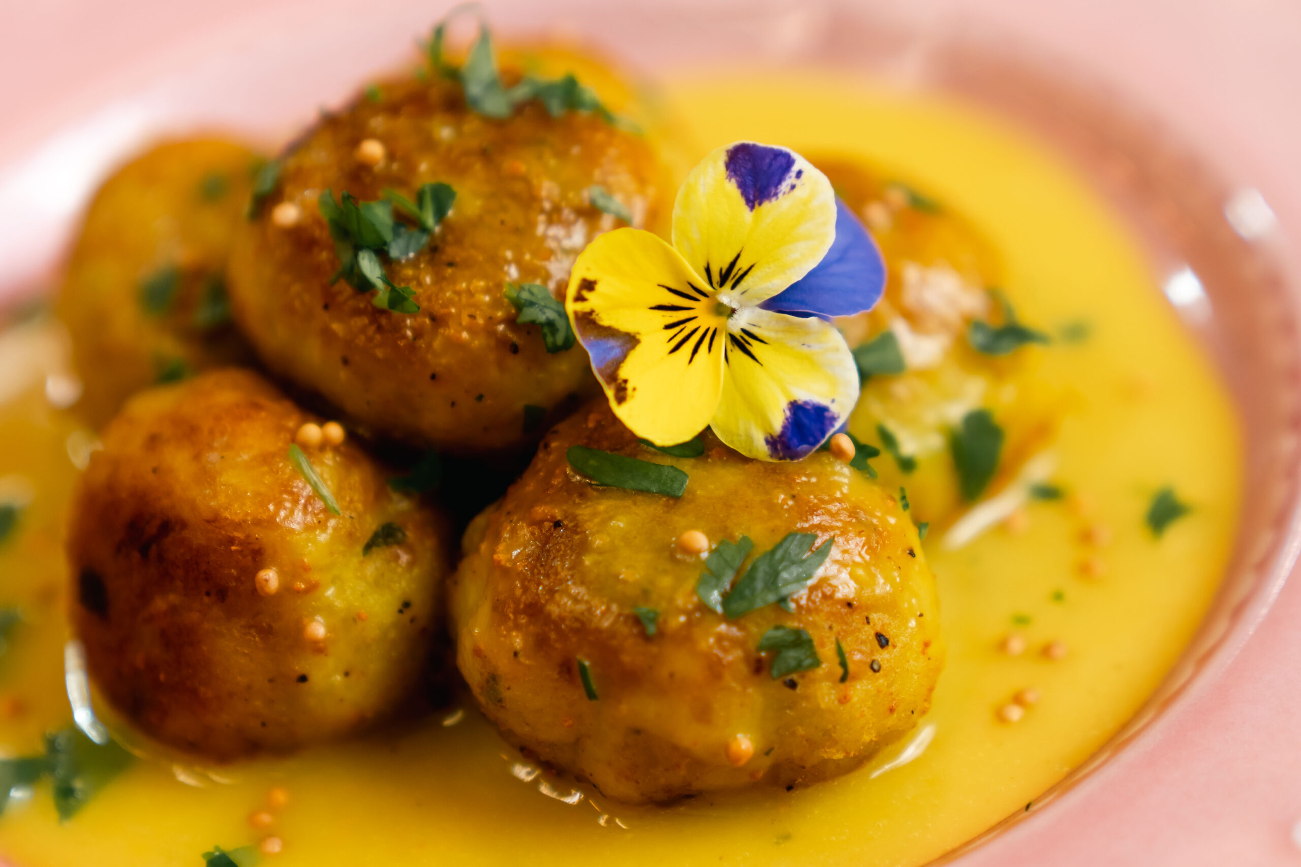 Polpette di melanzane vegane dorate in padella, speziate con curcuma e pepe nero